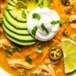 A bowl of creamy keto white chicken chili with avocado and lime.