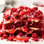A full strawberry red velvet dump cake with creamy layers, sliced strawberries, and a crumb topping.